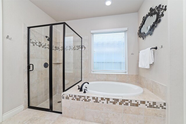 full bath with tile patterned floors, a bath, and a stall shower