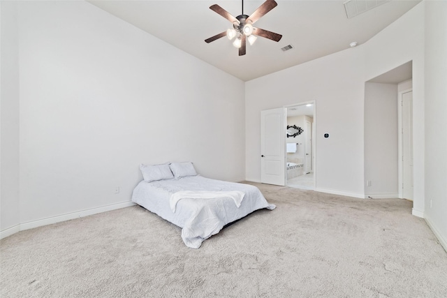 carpeted bedroom with visible vents, baseboards, vaulted ceiling, and ensuite bathroom