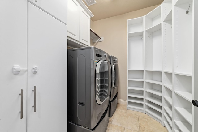 clothes washing area featuring visible vents, cabinet space, and washing machine and dryer