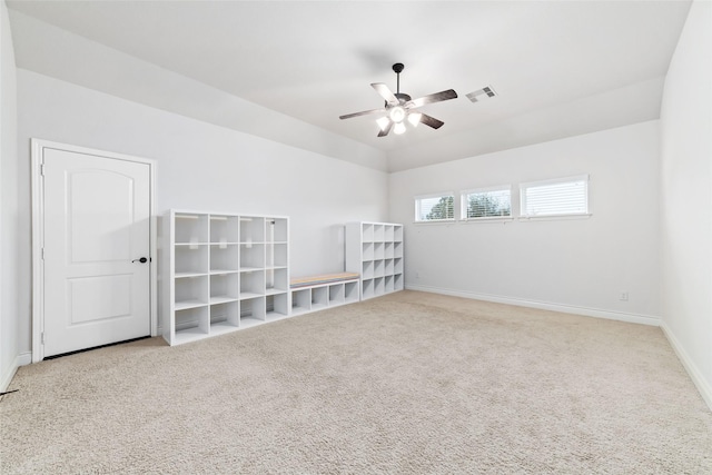 carpeted spare room with visible vents, baseboards, and a ceiling fan