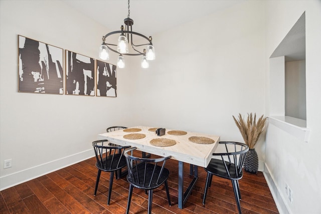 dining area featuring dark wood-type flooring and a notable chandelier