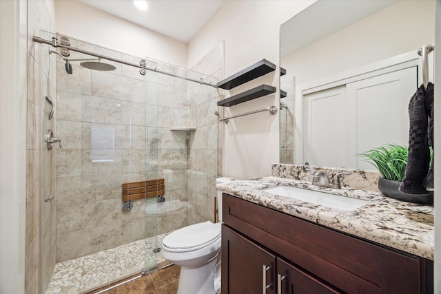 bathroom with vanity, toilet, and a shower with shower door