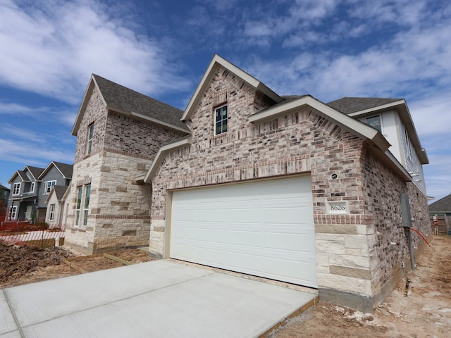 8626 Sun Coral Dr, Cypress, TX 77433 - view of front of property featuring concrete driveway, stone siding, brick siding, and roof with shingles