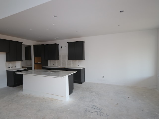 8626 Sun Coral Dr, Cypress, TX 77433 - kitchen featuring concrete floors, a kitchen island, and dark cabinetry