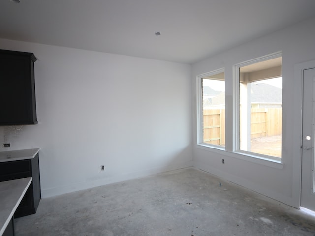 8626 Sun Coral Dr, Cypress, TX 77433 - unfurnished living room featuring unfinished concrete flooring, plenty of natural light, and baseboards