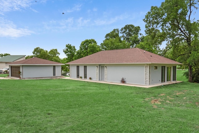 rear view of house featuring a garage and a yard