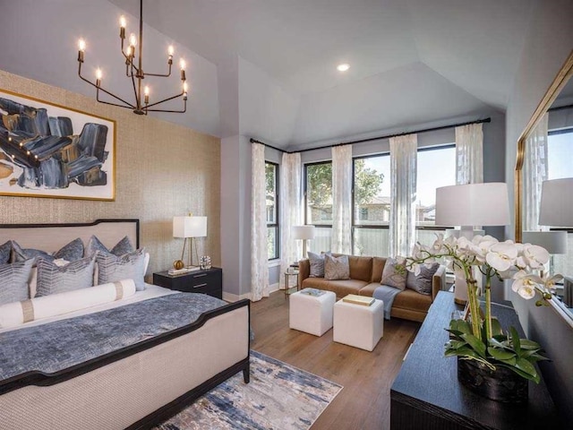 bedroom with wood finished floors, an inviting chandelier, baseboards, and vaulted ceiling