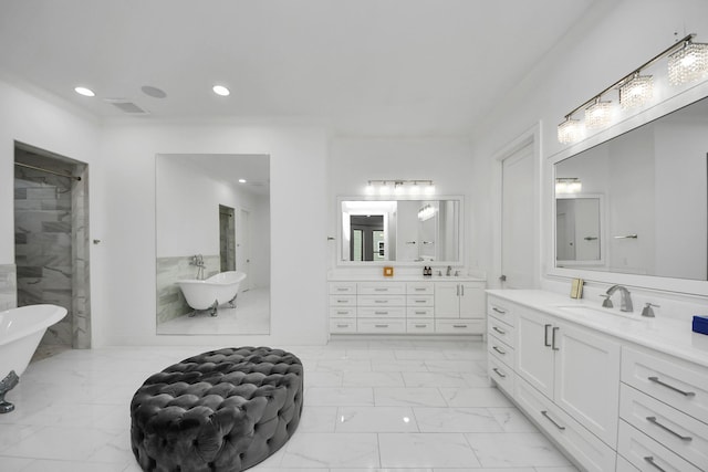 bathroom featuring marble finish floor, two vanities, a soaking tub, and a sink