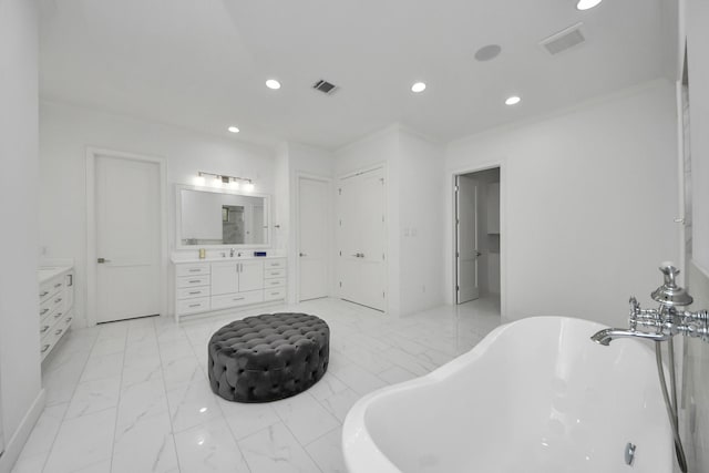 full bath with recessed lighting, vanity, a freestanding bath, marble finish floor, and a closet