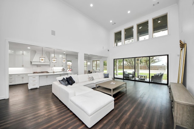 living area with dark wood-type flooring, visible vents, and recessed lighting