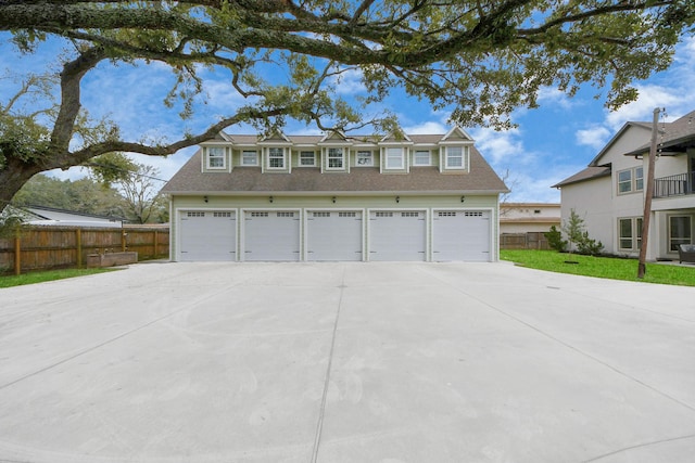 exterior space featuring a garage, driveway, and fence