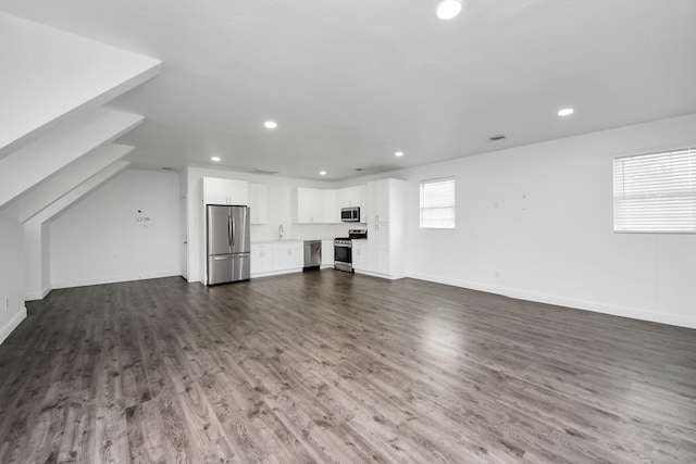 unfurnished living room featuring baseboards, wood finished floors, visible vents, and recessed lighting