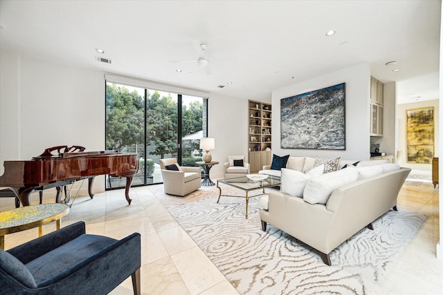 living room featuring ceiling fan, a wall of windows, and built in features