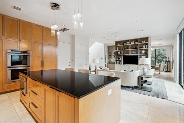 kitchen featuring ceiling fan, stainless steel double oven, decorative light fixtures, and a center island