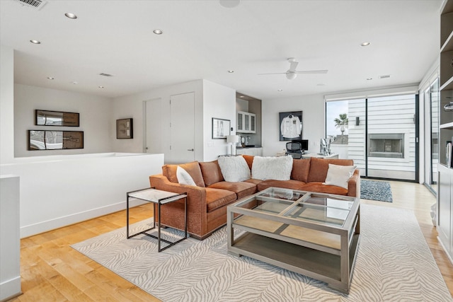 living room with ceiling fan and light wood-type flooring