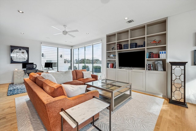 living room with ceiling fan, floor to ceiling windows, and light hardwood / wood-style floors