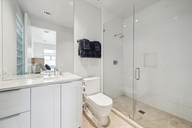 bathroom featuring vanity, toilet, and a shower with door