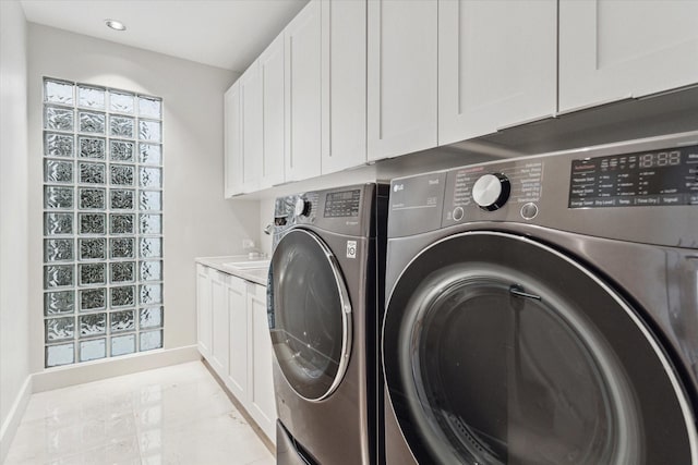 washroom with cabinets and washer and dryer