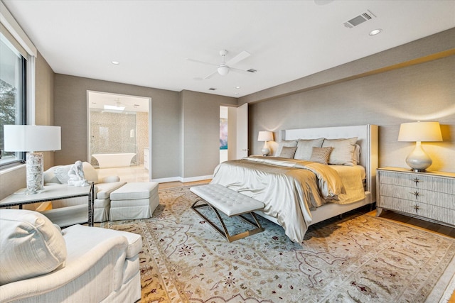 bedroom featuring light hardwood / wood-style flooring, ceiling fan, and ensuite bathroom