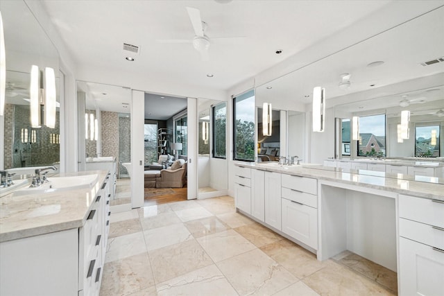 bathroom featuring vanity, a healthy amount of sunlight, ceiling fan, and a tub to relax in