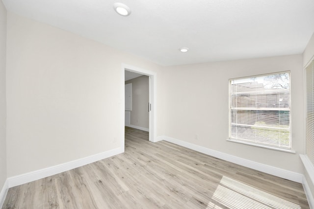 unfurnished room with recessed lighting, light wood-type flooring, and baseboards