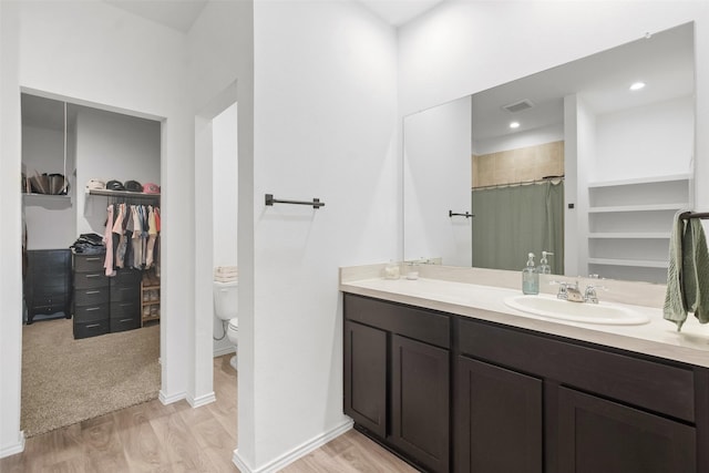 bathroom featuring hardwood / wood-style flooring, vanity, and toilet