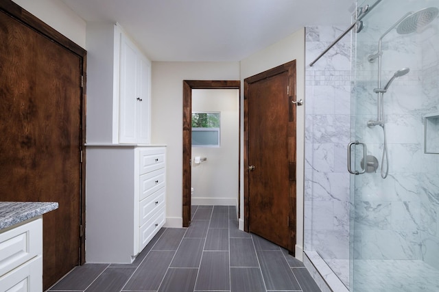 bathroom featuring vanity and a shower with door