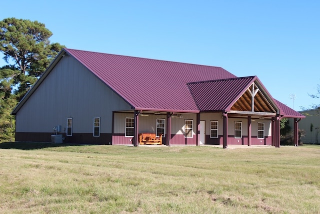 rear view of property with central AC unit, covered porch, and a lawn