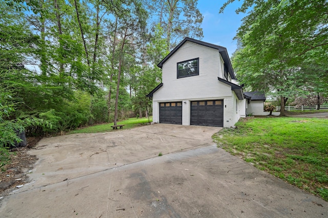 view of side of home featuring a garage and a lawn