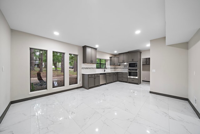 kitchen featuring stainless steel appliances, sink, and backsplash