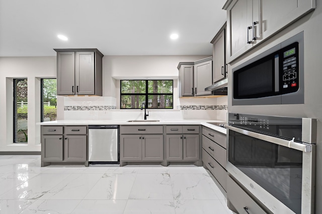 kitchen featuring gray cabinetry, sink, and appliances with stainless steel finishes