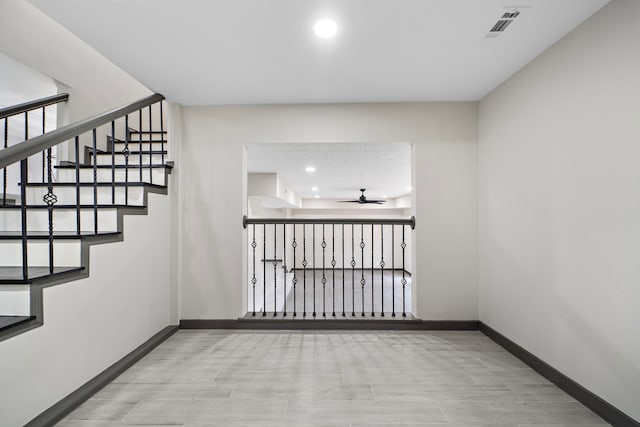 staircase featuring ceiling fan