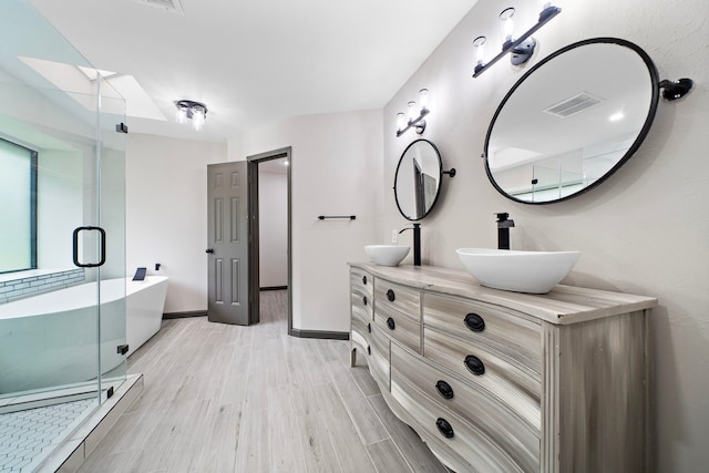 bathroom featuring vanity, separate shower and tub, and hardwood / wood-style floors