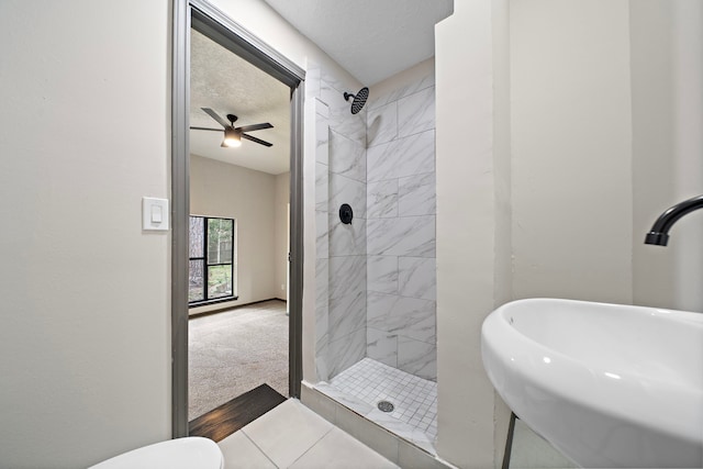 bathroom featuring tiled shower, sink, and a textured ceiling