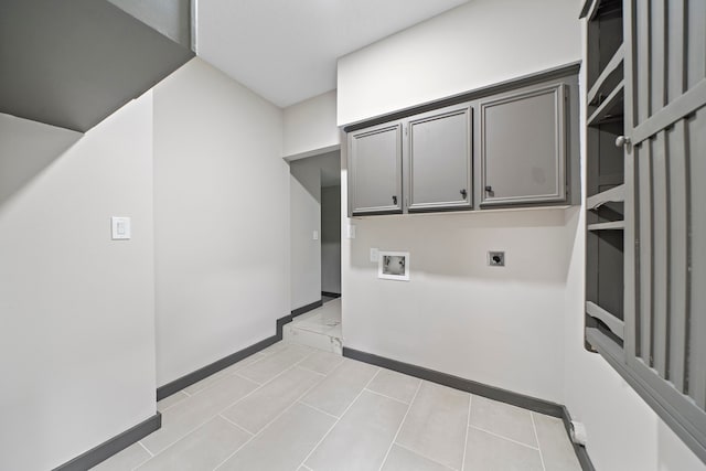 washroom featuring electric dryer hookup, washer hookup, light tile patterned floors, and cabinets