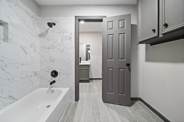 bathroom featuring tiled shower / bath combo and vanity