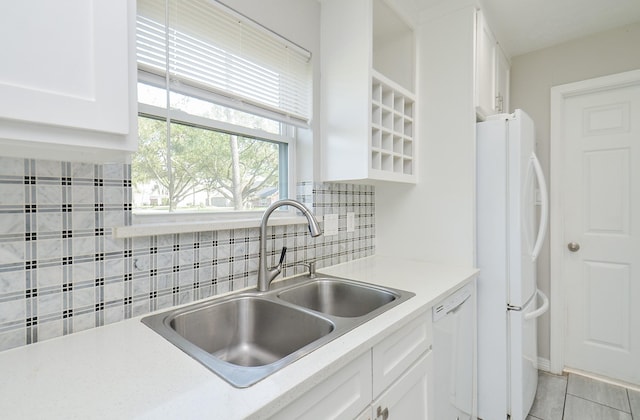 kitchen with light countertops, white appliances, white cabinets, and a sink