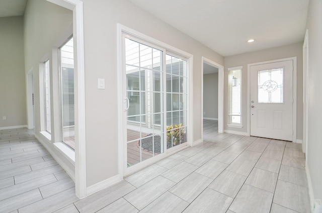 entrance foyer featuring wood tiled floor, baseboards, and recessed lighting