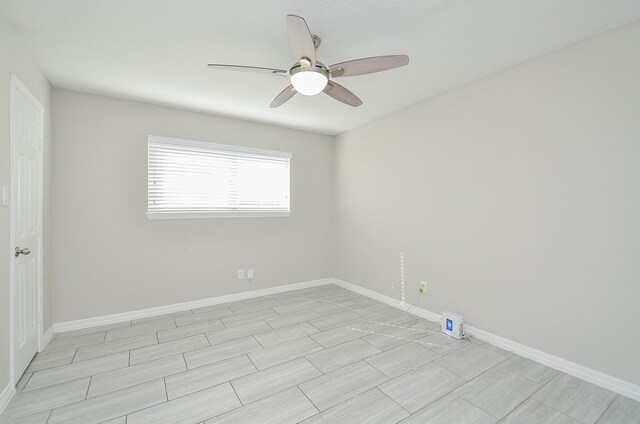 empty room featuring ceiling fan and baseboards