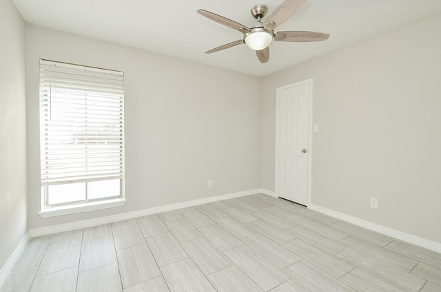 empty room featuring ceiling fan and baseboards