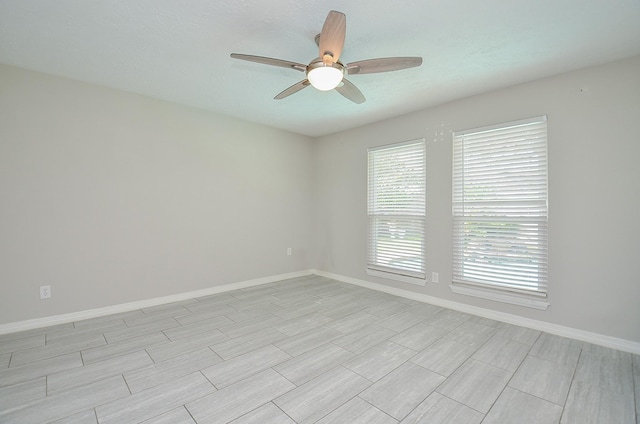 spare room featuring baseboards and a ceiling fan