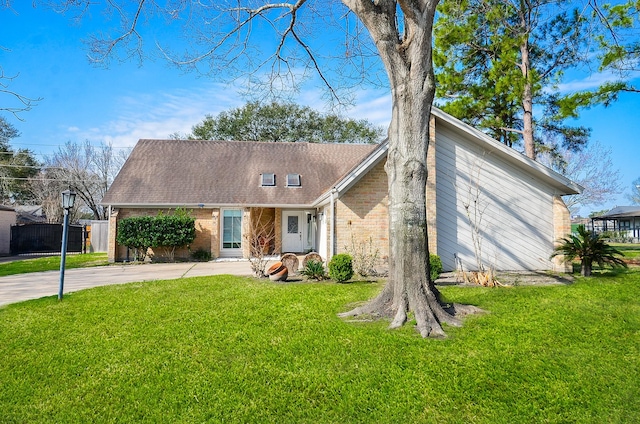 mid-century home with a shingled roof, brick siding, fence, concrete driveway, and a front lawn