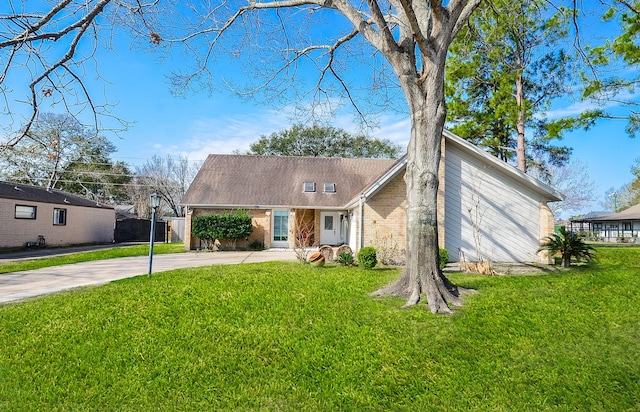 view of front of home with driveway, a front lawn, and brick siding