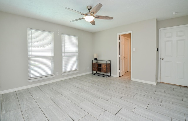 unfurnished living room with baseboards and a ceiling fan