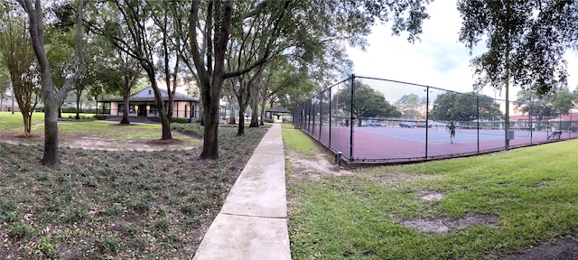 view of home's community with a tennis court, a lawn, a gazebo, and fence