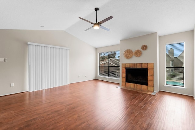 unfurnished living room featuring ceiling fan, vaulted ceiling, wood-type flooring, and a fireplace