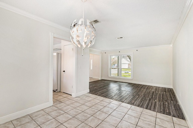 spare room with crown molding, an inviting chandelier, and light hardwood / wood-style flooring