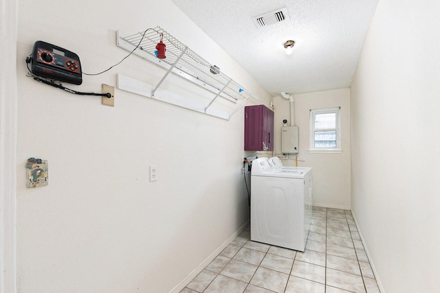 laundry room featuring tankless water heater, independent washer and dryer, light tile patterned floors, and a textured ceiling