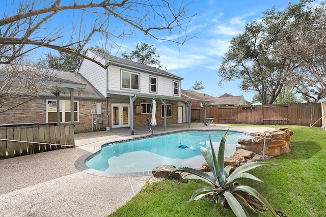 view of swimming pool featuring a lawn, a patio area, and french doors