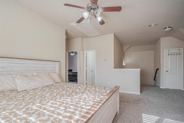 unfurnished bedroom with visible vents, a ceiling fan, carpet floors, attic access, and vaulted ceiling